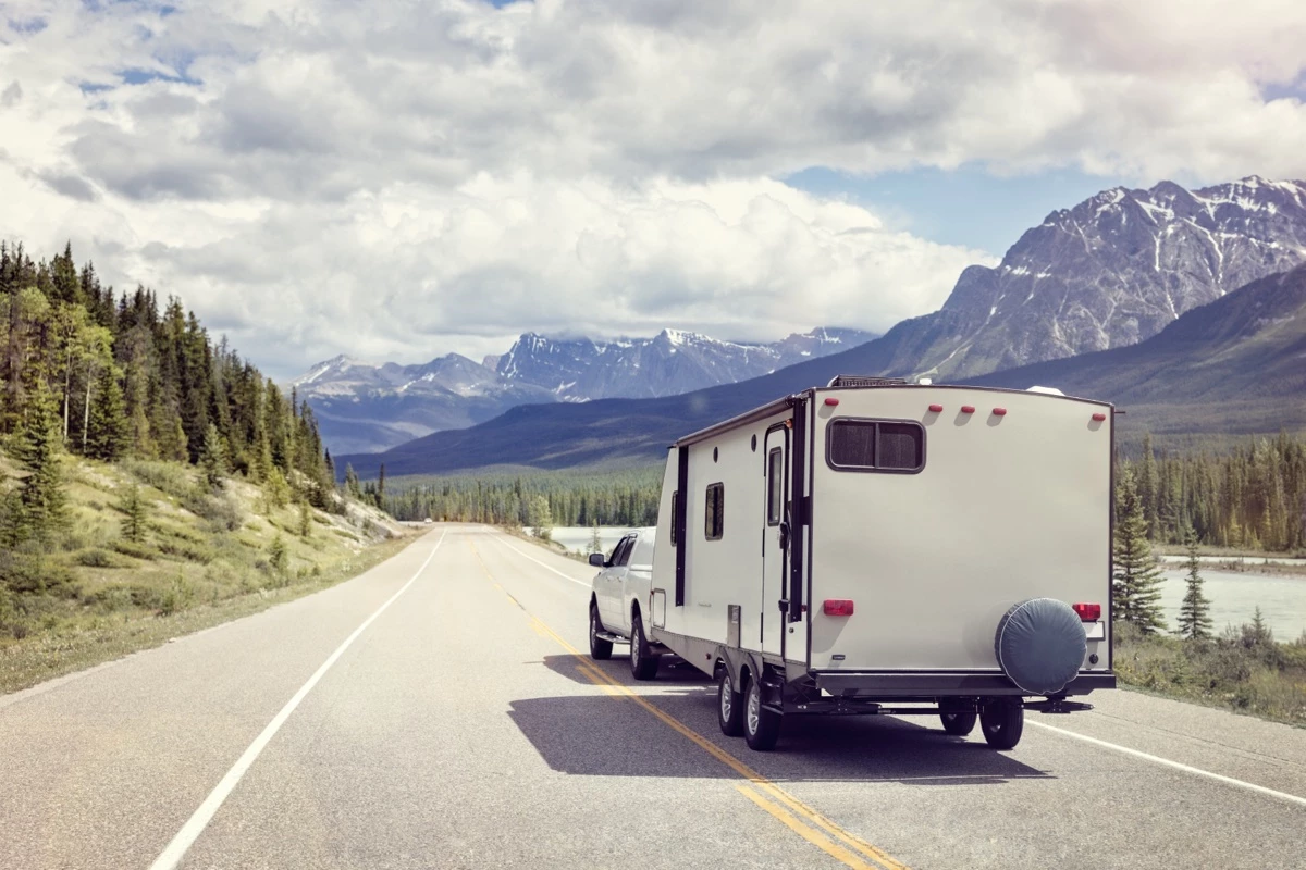 Un pick-up qui tire un roulotte sur la route.