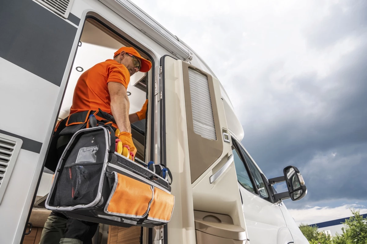 Un technicien qui rentre dans véhicule récréatif.