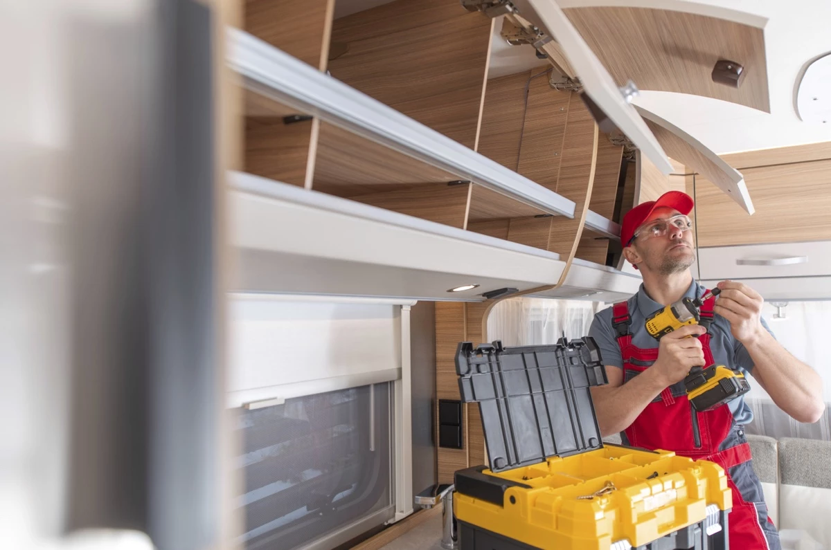 Un technicien qui remplace des poignets d'armoire.