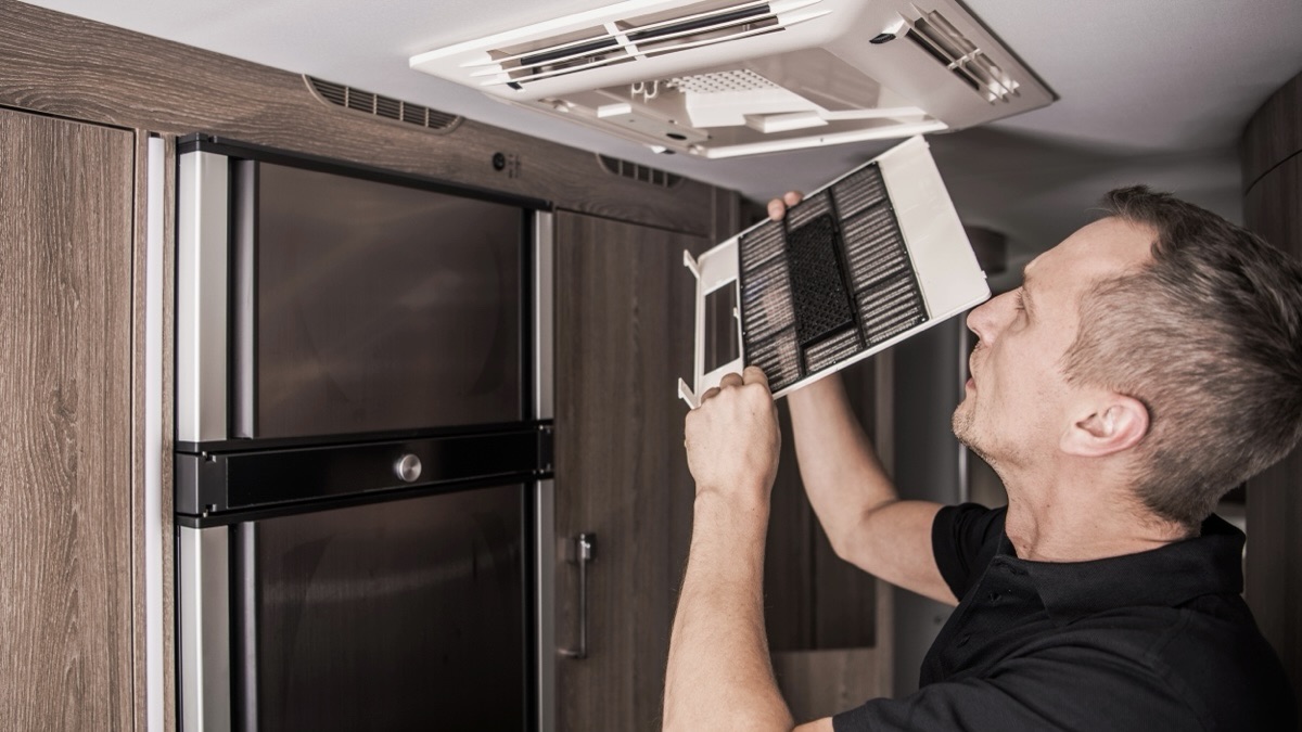 Un technicien qui déconnecte le système de chauffage d'une roulotte.